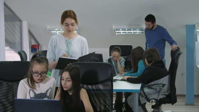 Teachers on class of elementary school students in a modern classroom during  STEM lessons