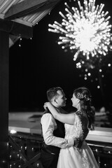 A newlywed couple watches a wedding fireworks display against