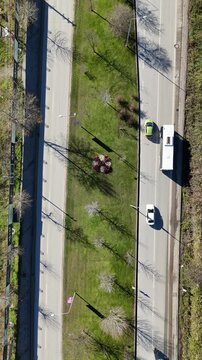 Top view aerial shot of an empty asphalt road with clear lane markings. Minimal and clean transportation background suitable for traffic concepts, urban infrastructure, travel, logistics, navigation, 