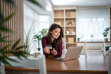 Woman shopping online at home using credit card