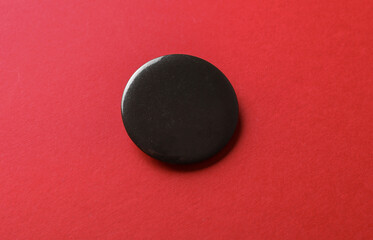 Black round pin button badge mockup on red background