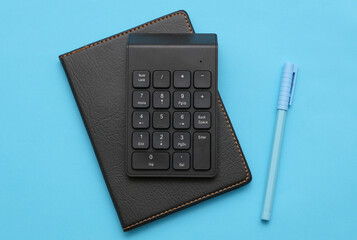 Additional mini keyboard and notebook on red background. Office accessories