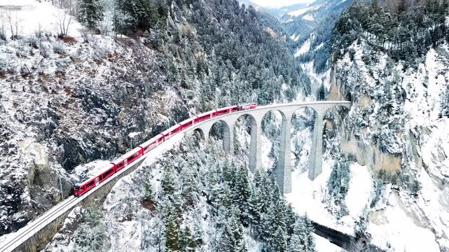 Aerial view of train passing through famous mountain in filisur landwasser viaduct world heritage with train express in swiss alps snow winter scenery