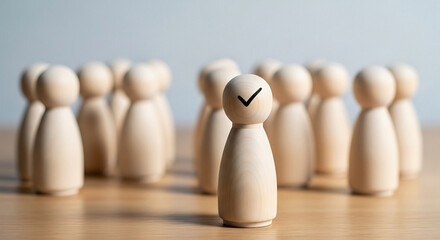 Wooden figurines with one having a check mark on its head in a row on a wooden surface light wood