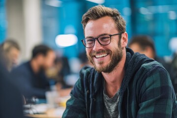 attractive Dutch tech male worker in open space office or coworking space wearing casual clothes, laughing with colleagues, candid collaboration moment