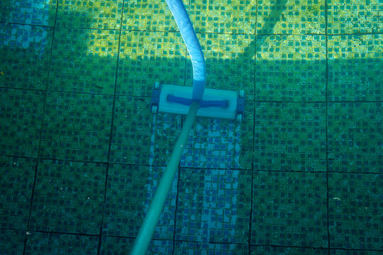 A pool cleaner at the bottom of a dirty swimming pool