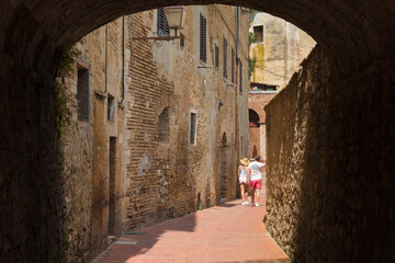 Fototapeta premium Children in Medieval Alley, San Gimignano Italy