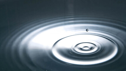 Minimal water ripple with a single droplet splash, perfect for concepts of calm, purity, mindfulness, science, meditation visuals, and abstract backgrounds for commercial design.