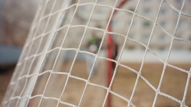 closeup of soccer net, detailed mesh and goal structure, sharp focus on net fibers and textures, clear image showing sports field tension and intricate net details