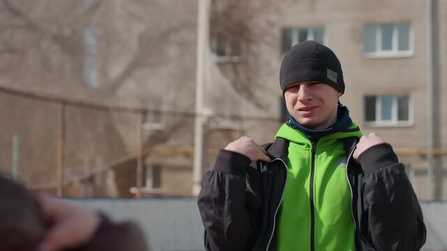 individual sporting neon hoodie exhibiting expressive movements and selfassurance, athlete in energetic city clothing striking confident pose while showcasing vivid apparel and gestures