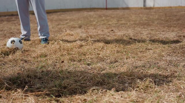 player focuses patiently, kicker concentrates before striking, individual steadies themselves prior to executing kick, competitor maintains composure while honing foot positioning for precise shot