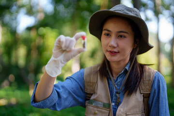Asian botanical researcher collecting studying plant samples nature outdoors field scientist examining ecological data natural environment conservation forest wildlife exploration