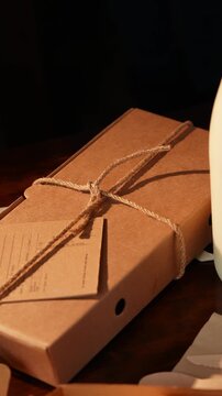 A brown box with a tag on it and a string tied around it. The box is on a table