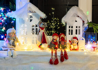 Christmas view from a white cardboard house, various gnome figures, colorful lights, home interior decor, festive mood