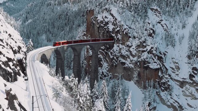 Aerial view of train passing through famous mountain in filisur landwasser viaduct world heritage with train express in swiss alps snow winter scenery