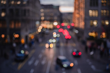 Blurred city street at night with traffic lights creating a bokeh effect and moody atmosphere