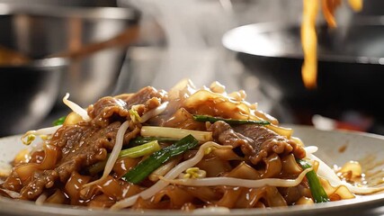 Delicious and steaming hot stirfried beef noodles known as Hor Fun or Chow Fun being expertly served with chopsticks directly from a wok in a bustling Asian kitchen showcasing fresh ingredients and a.
