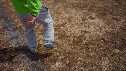 side view passing and control on dry pitch, player in bright green jersey practicing touches; casual warmup sequence, measured trajectory and foot placement, community field backdrop for lifestyle
