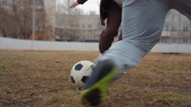 closeup of ball mastery and swift maneuvers, two athletes perform rapid succession of passes demonstrating control and tactical offensive and defensive strategies in gritty city environment
