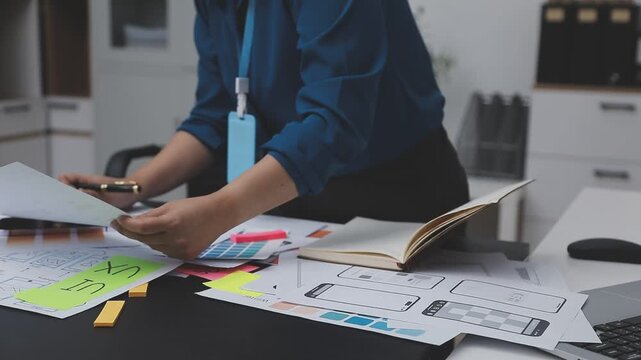 Professional woman working on UXUI design, creating wireframes and mockups for a mobile application while on a call