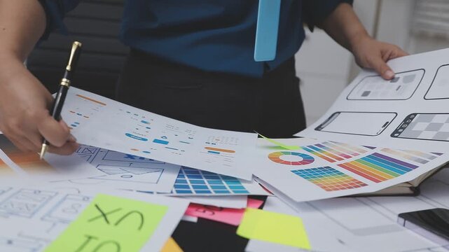 Professional woman working on UXUI design, creating wireframes and mockups for a mobile application while on a call