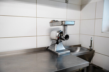 Manual stainless steel pasta machine on kitchen counter