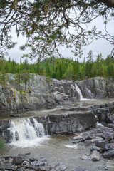 Rocky forest waterfall cascading through granite gorge in southern Norway