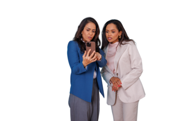 Two businesswomen colleagues sharing a smartphone, looking surprised and worried at content on a transparent background