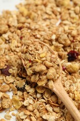 Obraz premium Tasty granola and spoon on white table, closeup
