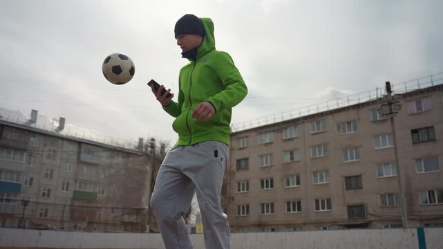 dynamic shot of citybased footballer, caucasian athlete executing volley kick on city soccer field, vigorous scene of lightskinned player performing energetic volley on urban football pitch