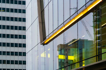 Modern glass office building facade in Warsaw, architectural detail with lighting and urban reflections