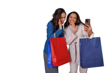 Two happy women shopping, holding bags and making a video call on smartphone, enjoying friendship and consumerism