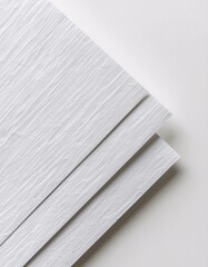 Diagonal stack of white textured sheets, minimalist studio shot