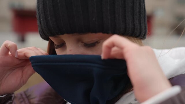 closeup of woman adjusting mask, urban background with woman delicately adjusting protective face gear, detailed snapshot of woman carefully positioning her mask amidst city surroundings