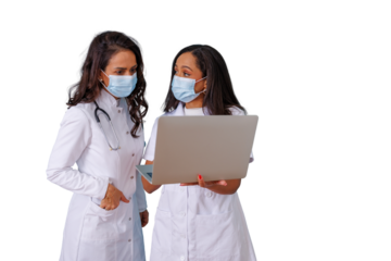 Healthcare workers wearing face masks discussing medical data on laptop, collaborating on health solutions