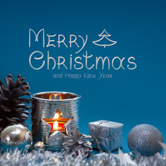 Advent candle with Christmas decoration isolated on blue.