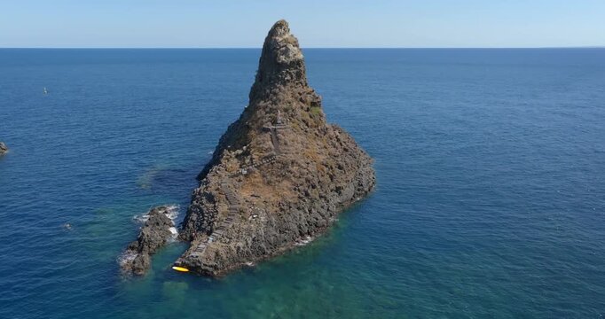 Aerial close up of the Cyclopean Isles, noted for their rows of basaltic columns piled one above another, lie not far from Aci Trezza off the eastern coast of Sicily in the Mediterranean Sea, Italy. 