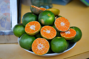 Fresh ripe oranges displayed on a plate in Pattaya, Thailand, highlighting the vibrant colors and freshness of local produce