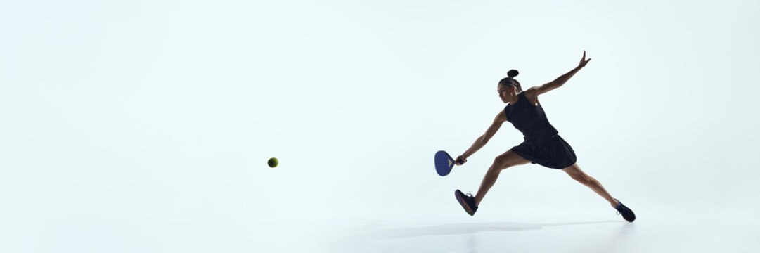 Female athlete lunging forward to reach ball isolated on white. Concept of sports technique, winning strategy, execution skills, and outcome-focused business processes. Banner - Powered by Adobe