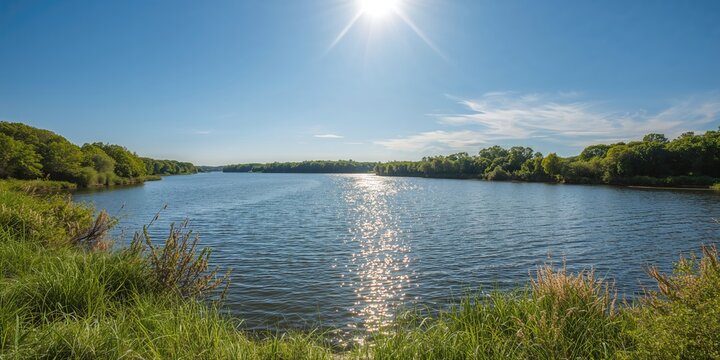 Water-filled quarry shoreline with lush forest and summer sky, natural landscape features
