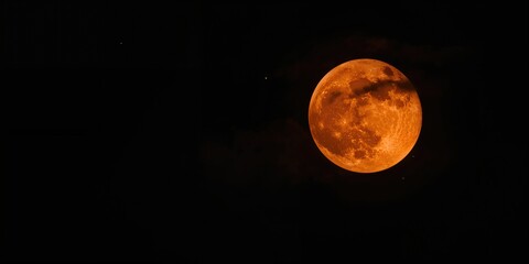 Bright orange moon against a black sky, highlighting nocturnal celestial events and lunar visibility