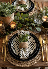 Rustische Festtafel mit gepunktetem Geschirr, Goldbesteck und Eukalyptus