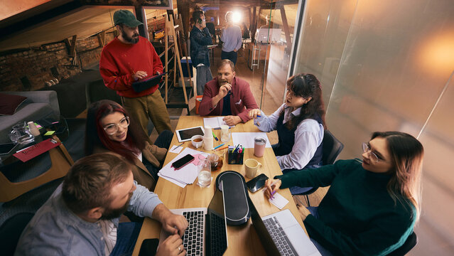Business team gathered around table discussing project ideas. Concept of teamwork, brainstorming, strategic planning, startup collaboration, and modern office workflow. - Powered by Adobe