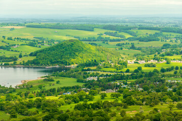 Penrith, Ullswater, Lake District. Panoramic countryside landscape with lake, rolling hills, and village in green fields