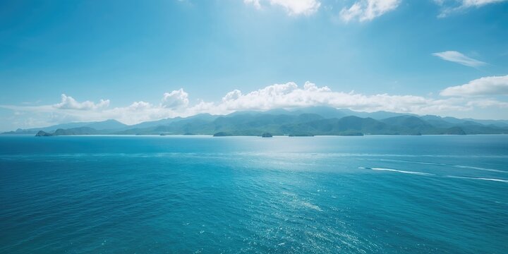 Sea and mountain scenery featuring blue water and lush forested peaks, suitable for nature-themed layout or website backdrop
