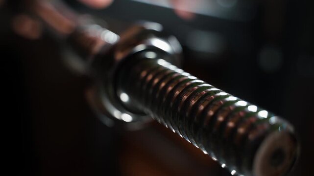 Unscrewing the nut on the barbell for training, close-up on a blurred background