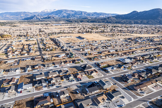 Aerial view of rooftops spread across the town beneath the snow-capped Collegiate Peaks, a symphony of urban and natural beauty, Buena Vista, Colorado, United States.