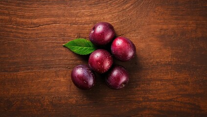 Green and blue ripe plums on a wooden background emphasizing natural produce, World Food Day