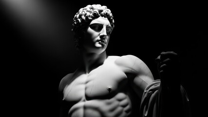 A black and white photo of a classical male statue with dramatic top lighting.
