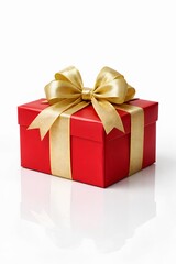 Fototapeta premium Red Christmas gift box with a large elegant golden ribbon bow isolated on a white background with a soft reflection.